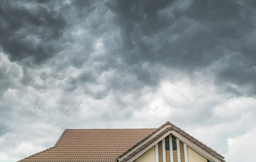 hail damage-shingled roof under a stormy sky