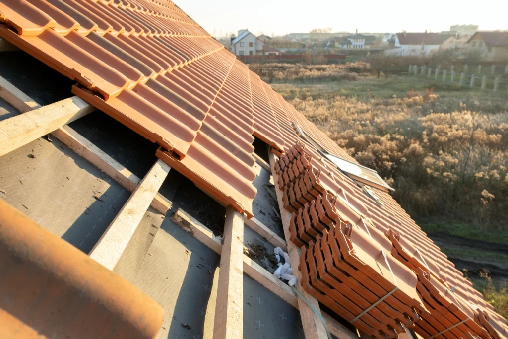 install roof shingles-close up view of a red roof in progress of being shingled