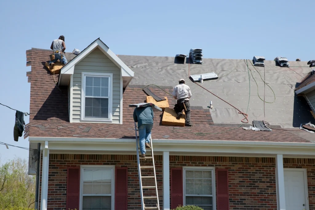 insurance-Front of house with workers on roof