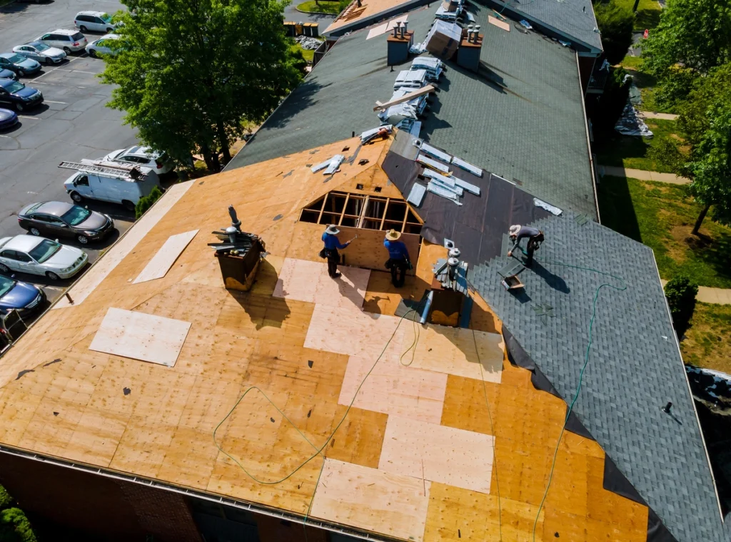 insurance-arial view of roof repair techs laying shingles on a roof