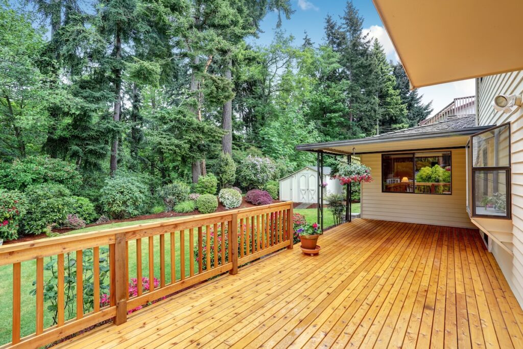 Wooden walkout deck. Well kept garden with bushes and flowers. Northwest, USA
