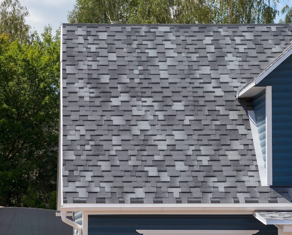 The roof of the house lined with gray bitumen shingles impact resistant shingles
