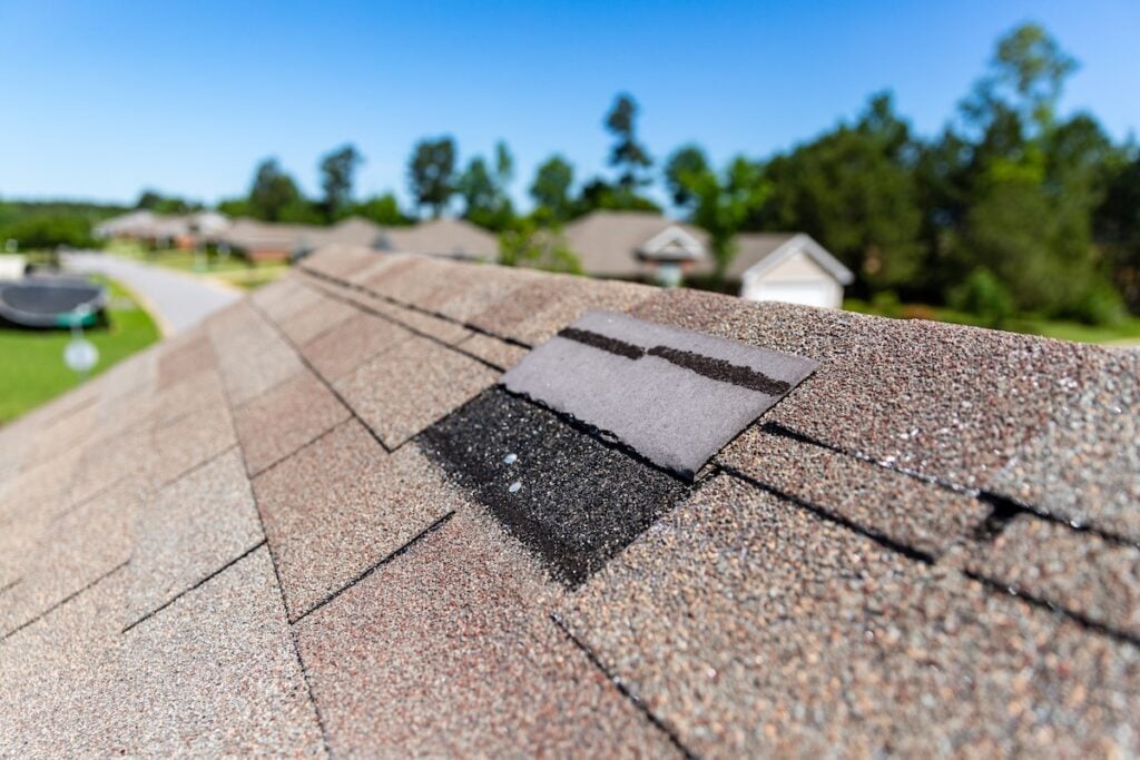 Missing shingles on roof due to storm damage.