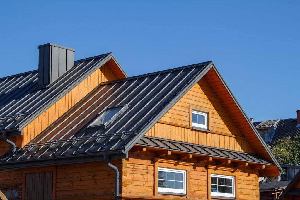 types of siding Wooden houses. Classic metal roof. Colorful Houses