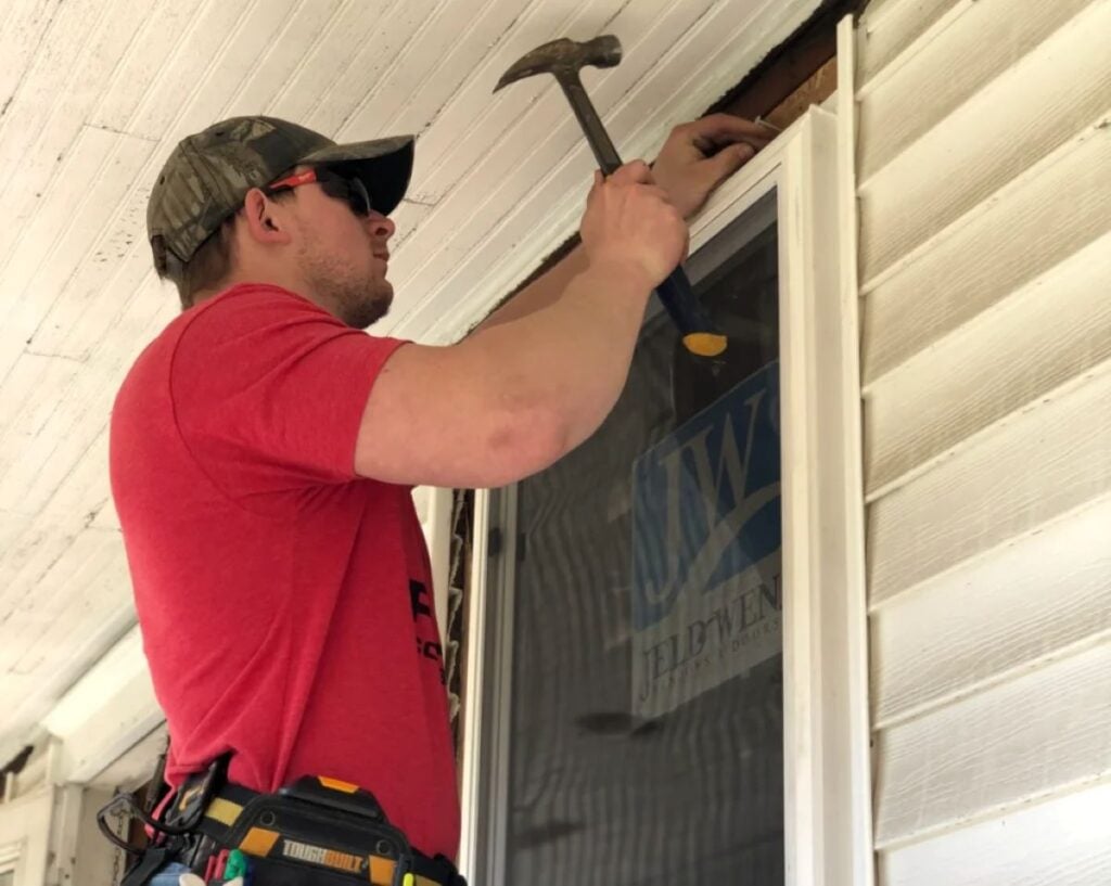 andersen windows cost Puez Construction worker installing window in american house white ceiling and wall
