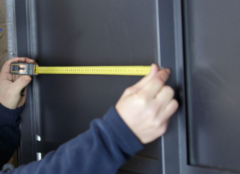 construction worker measuring width of door frame