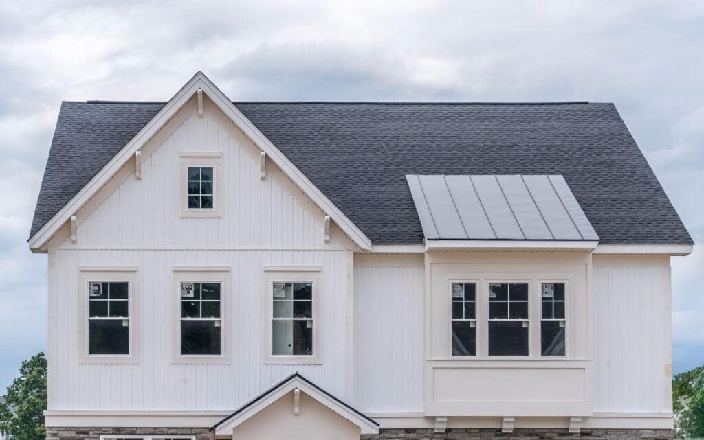 cream color vertical siding with grey roof big tall house