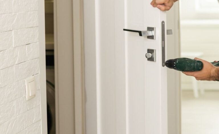 handyman fixing a door lock in a house entrance