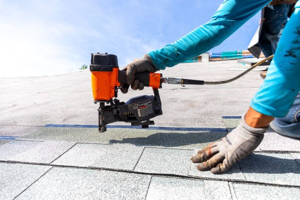 installing roof shingles with nail gun