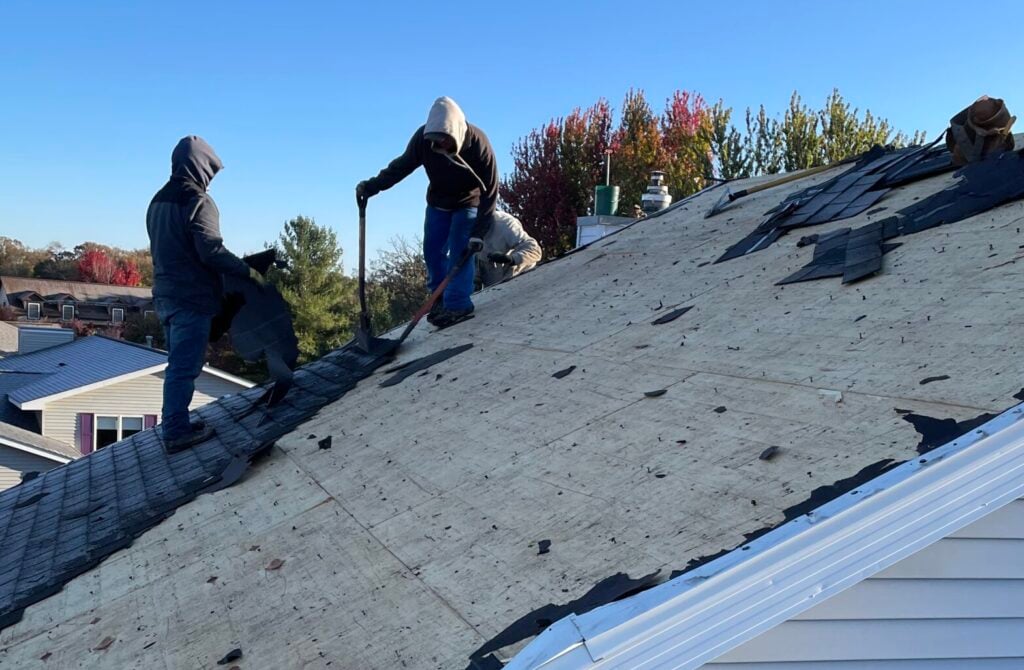 Two roofers from Puetz Construction repairing a roof