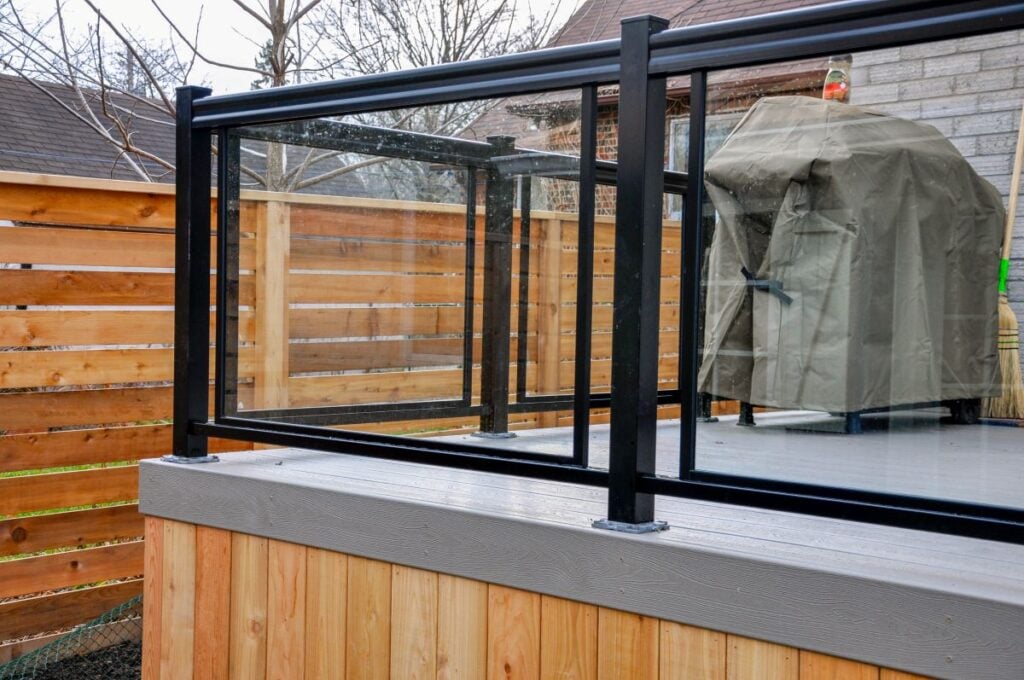 A newly constructed backyard deck uses wood composite, cedar skirting