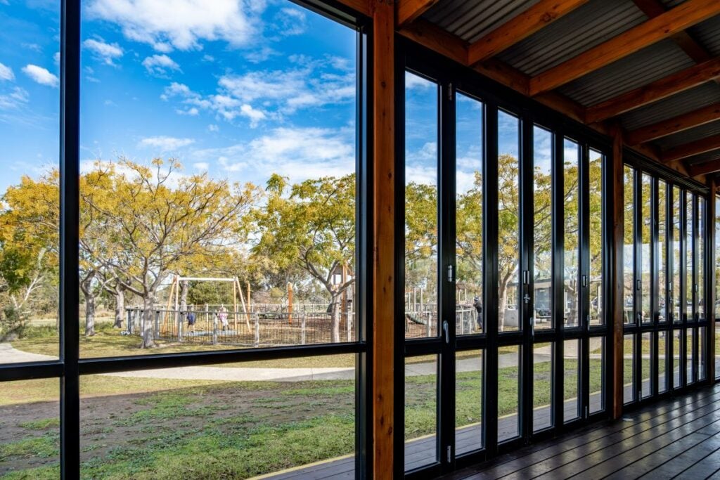 An enclosed patio or covered outdoor seating area with bi-fold glass doors