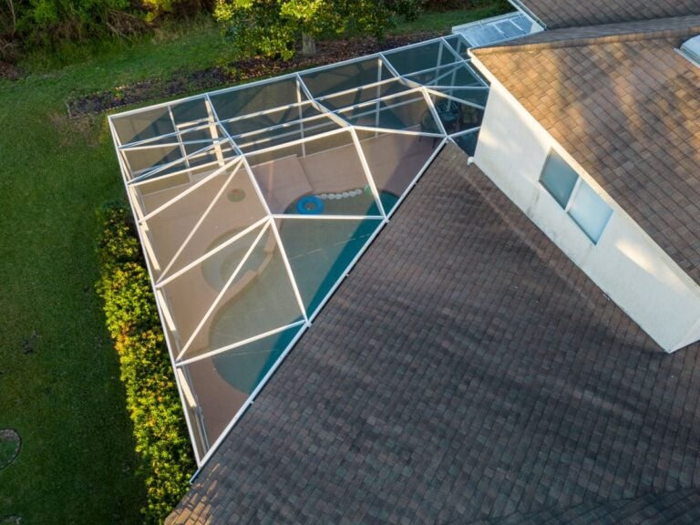 Pool screen enclosure connected to house and roof
