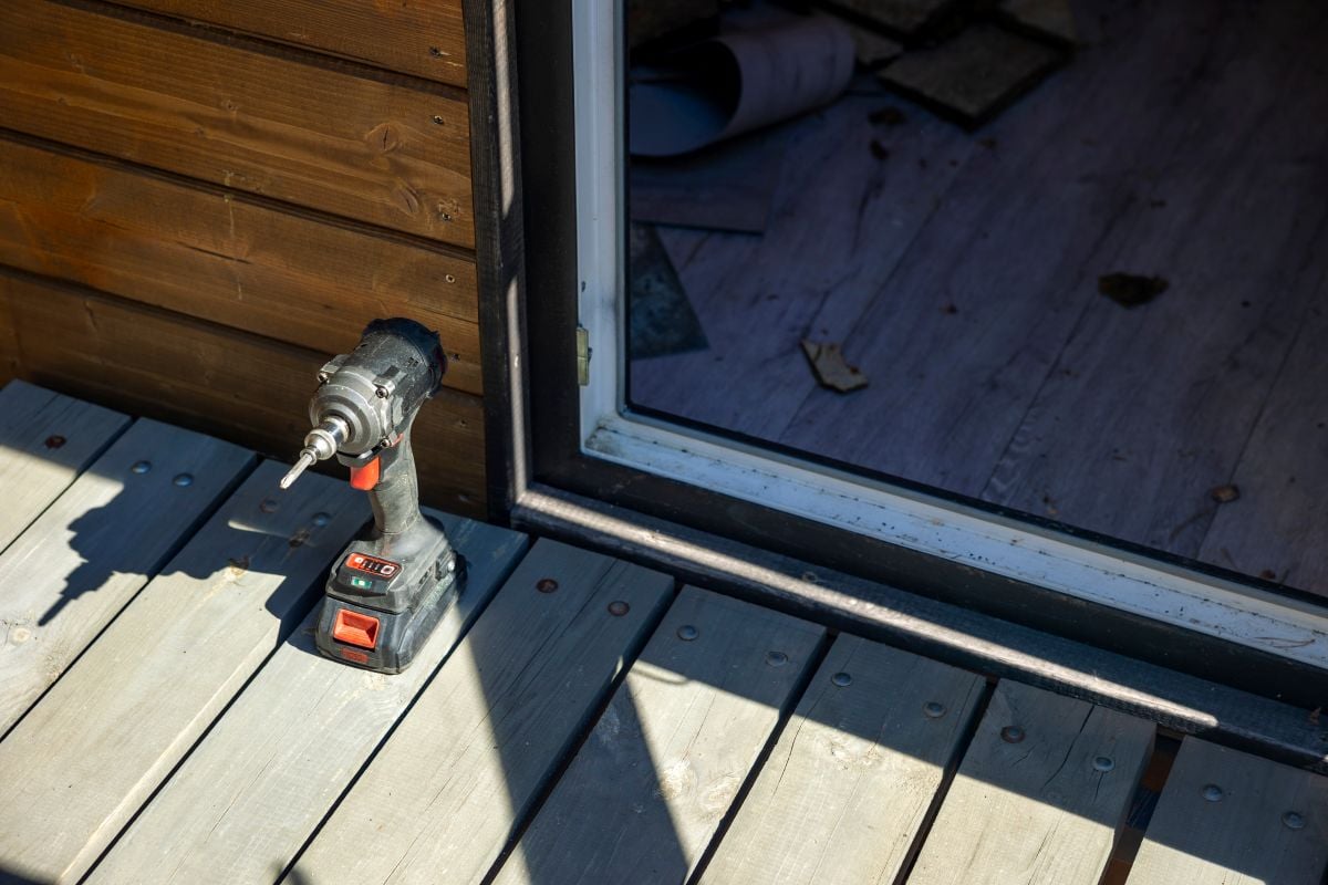 driver on wooden deck at private house entrance, sunny outdoor workspace