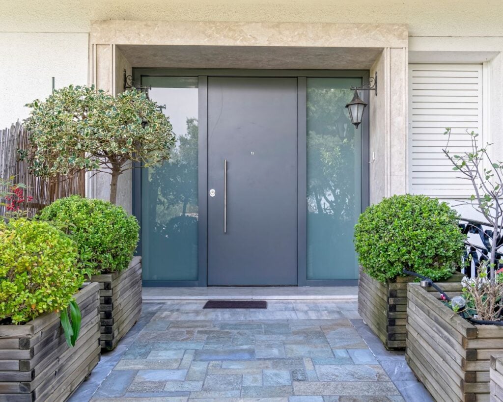 modern family house front entrance stone covered corridor to metal and glass door
