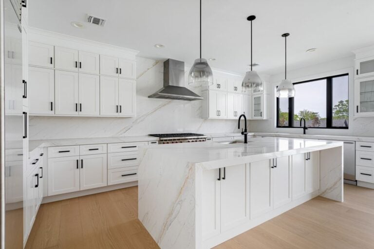 Bright modern white kitchen with large marble island and pendant lighting, luxury residential kitchen interior with minimalist contemporary design