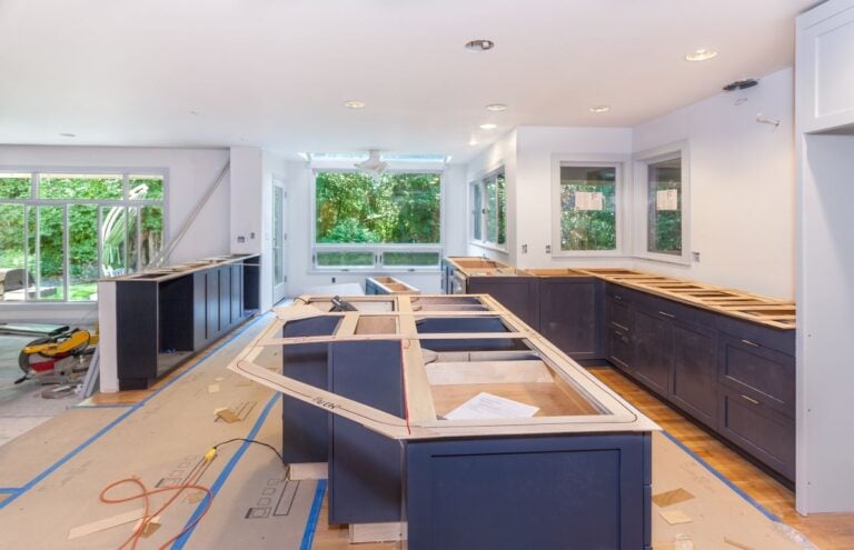 Cutting and marking wood templates for making engineered stone countertops. Kitchen remodel in progress.