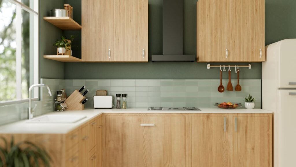 Interior design of a modern green kitchen with kitchen appliances, wooden cabinets, and green wall.
