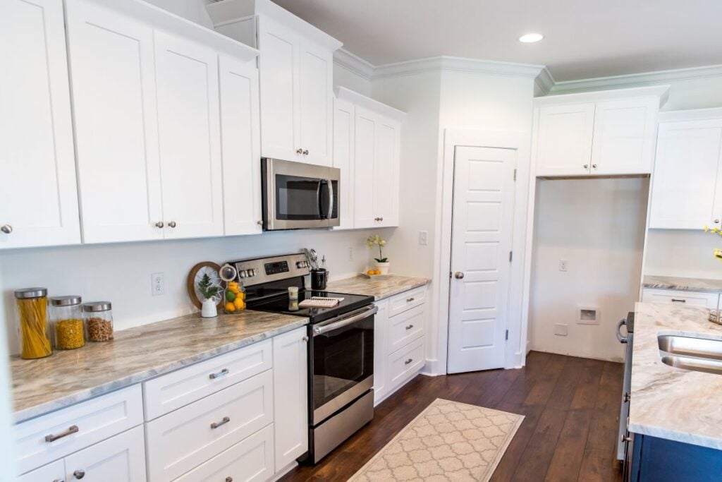 New construction modern kitchen with white cabinets and hardwood floors
