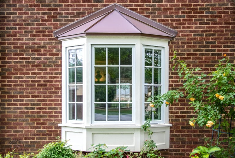 Bay window with copper roof and greenery