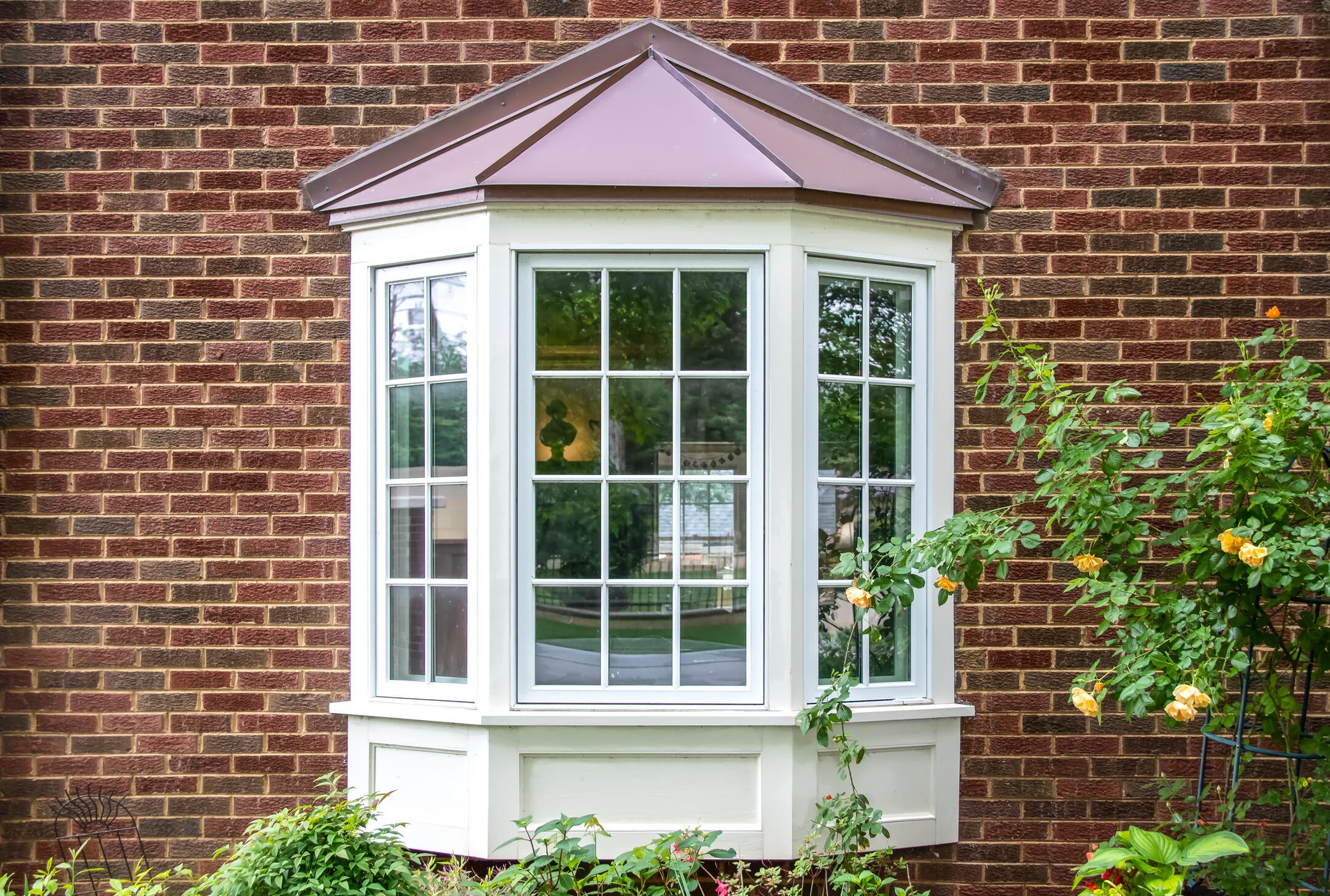 Bay window with copper roof and greenery