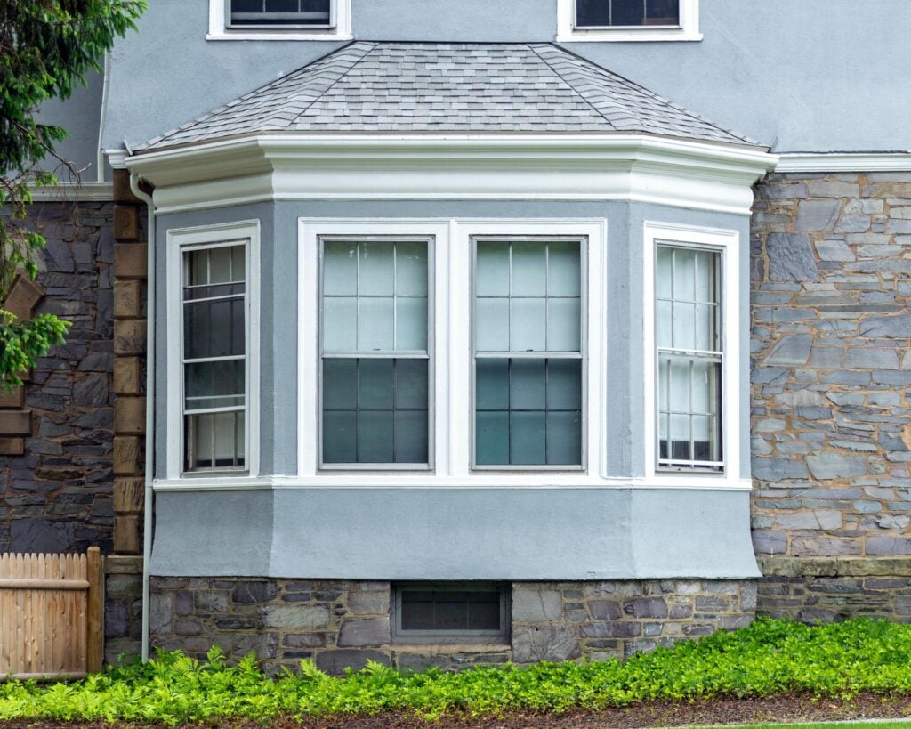 Traditional home exterior with bay window and stone-stucco facade